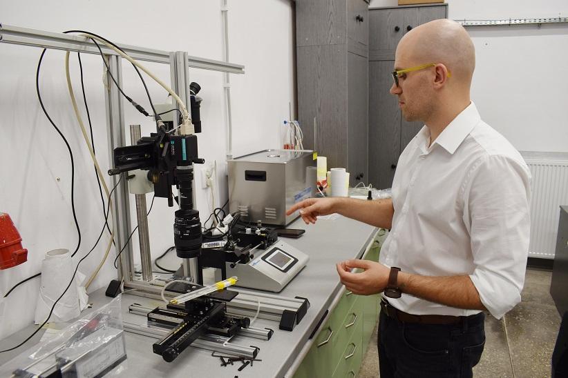 Dr inż. Krzysztof Wojtas pokazuje stanowisko badawcze, na którym wykonywane są pomiary laserowe prędkości.